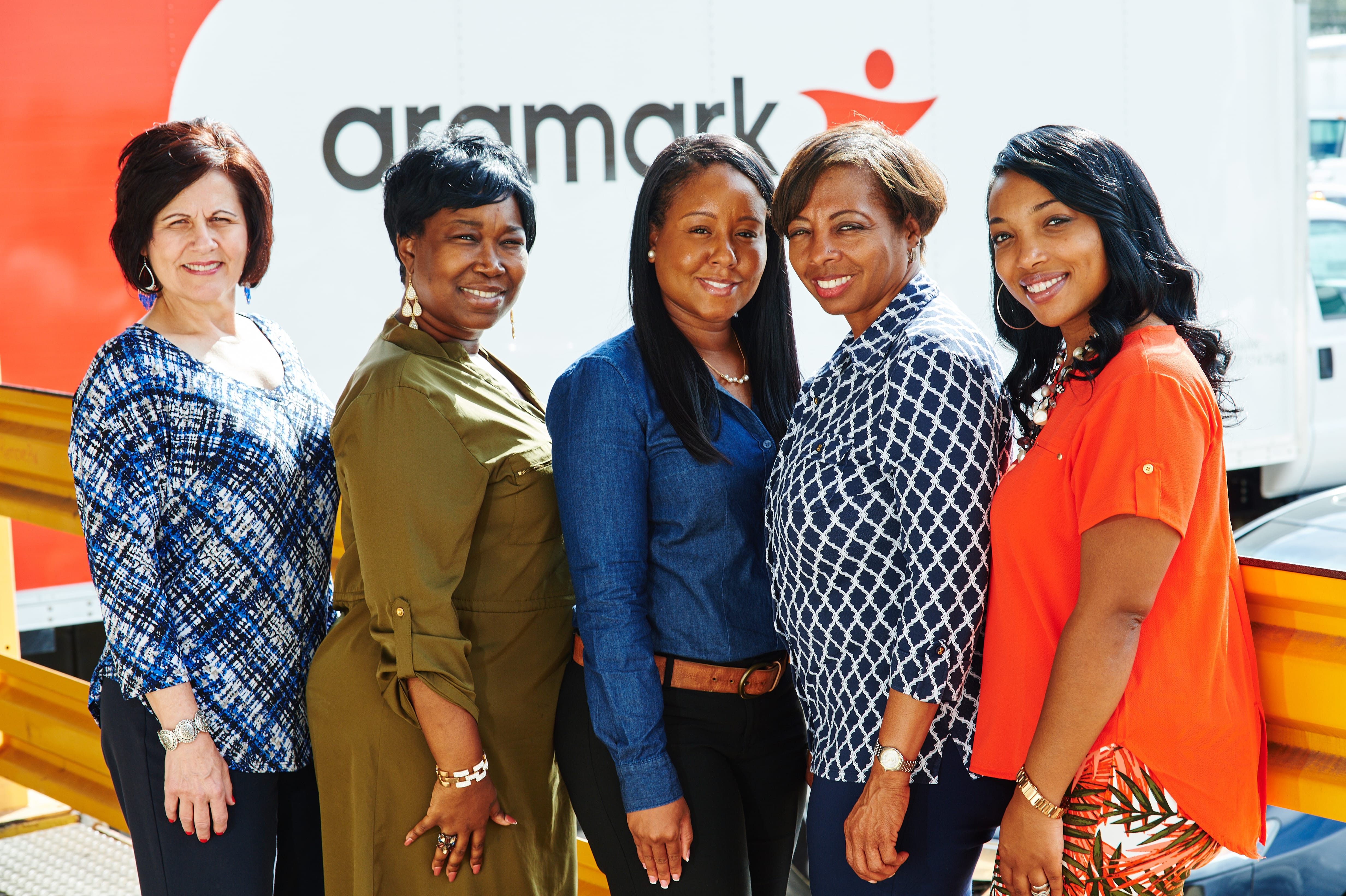 five women standing in front of Aramark truck